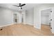 Spacious bedroom featuring hardwood floors, a modern ceiling fan, and an attached walk-in closet at 1306 Yates St, Denver, CO 80204