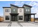 Modern two-story home featuring a stylish exterior with a combination of light and dark siding under a partly cloudy sky at 1306 Yates St, Denver, CO 80204