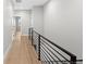 Hallway view featuring hardwood floors, modern railing, and access to multiple rooms at 1306 Yates St, Denver, CO 80204