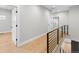 Upstairs hallway featuring hardwood floors, modern railing, and a neutral color palette at 1306 Yates St, Denver, CO 80204