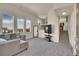 Cozy living room with plush carpeting, large windows, and neutral-toned sectional sofa at 1651 Aspen Meadows Cir, Denver, CO 80260