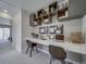 Contemporary office nook with floating desk, overhead shelving, and gray carpeting at 13079 E 103Rd Pl, Commerce City, CO 80022
