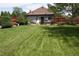 Spacious backyard with lush green lawn, mature trees, privacy fence, and comfortable seating area at 5095 Grant St, Denver, CO 80216