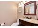 Elegant half bathroom features a granite countertop, wood cabinetry, and stylish decor at 11056 W Rowland Ave, Littleton, CO 80127
