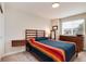 Bedroom featuring a queen bed with a horizontally slatted headboard and an adjacent wall-mounted nightstand at 11056 W Rowland Ave, Littleton, CO 80127