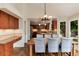 Spacious dining room with wood table and chairs leading into kitchen at 11056 W Rowland Ave, Littleton, CO 80127