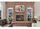 A classic brick fireplace with a painting, decorative shelves, and a cozy atmosphere at 11056 W Rowland Ave, Littleton, CO 80127