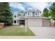 Charming two-story home featuring a three-car garage, manicured lawn, and mature landscaping at 11056 W Rowland Ave, Littleton, CO 80127