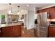 Granite countertop island with stainless fridge and hardwood flooring at 11056 W Rowland Ave, Littleton, CO 80127