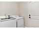Bright laundry room with white appliances and a white door at 11056 W Rowland Ave, Littleton, CO 80127
