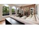 Bright living room with large arched windows, brick fireplace, built-in shelving, and comfortable seating at 11056 W Rowland Ave, Littleton, CO 80127