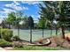 Community Tennis court is surrounded by lovely landscaping and greenery with a secure fenced perimeter at 11056 W Rowland Ave, Littleton, CO 80127