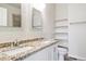 Bathroom featuring a double sink with granite countertop and decorative mirror at 85 Uinta Way # 405, Denver, CO 80230