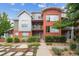 Contemporary two-story brick townhome with metal accents, landscaped yard, and walkway at 85 Uinta Way # 405, Denver, CO 80230