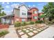Charming brick and metal townhouse with landscaped yard, walkway, and small patio area at 85 Uinta Way # 405, Denver, CO 80230