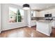 Spacious kitchen and dining area with island, white cabinetry, granite countertops, and hardwood floors at 85 Uinta Way # 405, Denver, CO 80230