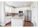 Modern kitchen with white cabinets, stainless steel appliances, granite countertops, and island at 85 Uinta Way # 405, Denver, CO 80230