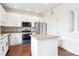 Bright, modern kitchen with white cabinetry, granite counters, island, and stainless steel appliances at 85 Uinta Way # 405, Denver, CO 80230