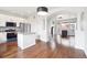 Open concept kitchen featuring an island, white cabinets, granite counters, and hardwood floors at 85 Uinta Way # 405, Denver, CO 80230