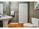 Updated bathroom with pedestal sink, wood floors, and white bifold closet for storage at 1745 Wazee St # 4G, Denver, CO 80202