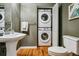 Bathroom featuring stacked washer and dryer inside closet, plus pedestal sink and toilet at 1745 Wazee St # 4G, Denver, CO 80202