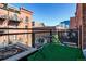Outdoor patio with artificial turf and a metal table and chairs with city views at 1745 Wazee St # 4G, Denver, CO 80202