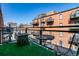 Outdoor patio with artificial turf and seating area, with views of the surrounding brick buildings at 1745 Wazee St # 4G, Denver, CO 80202
