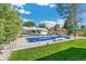 Lush backyard featuring a refreshing pool, well-manicured lawn, and a charming patio with seating at 2981 Teller St, Wheat Ridge, CO 80033