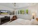 Bedroom featuring paneled walls, ceiling fan, shutters, and tv at 2981 Teller St, Wheat Ridge, CO 80033