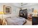 Well-lit bedroom with white walls, hardwood floors, and black bookshelves with vintage decor at 2981 Teller St, Wheat Ridge, CO 80033