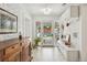 Bright hallway featuring white brick walls, tiled floor, and glass doors leading to a pool view at 2981 Teller St, Wheat Ridge, CO 80033