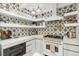 Close-up of a modern gas range and backsplash in a brightly lit chef's kitchen at 2981 Teller St, Wheat Ridge, CO 80033