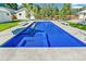 Bright blue swimming pool with modern design, surrounded by a spacious patio and landscaped backyard at 2981 Teller St, Wheat Ridge, CO 80033