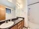Spacious bathroom featuring double sinks, a large mirror, and a shower-tub combo, offering a functional design at 6154 Quitman St, Arvada, CO 80003