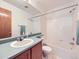 Well-lit bathroom featuring a shower-tub combo, single sink with a large mirror, and a clean, functional design at 6154 Quitman St, Arvada, CO 80003