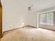 Spacious bedroom with large window, neutral carpet, and a ceiling fan at 6154 Quitman St, Arvada, CO 80003