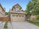 Traditional two-story home with attached garage, brick accents, and manicured landscaping at 6154 Quitman St, Arvada, CO 80003