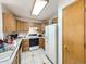 Functional kitchen featuring a white refrigerator, wood cabinets, and tile flooring providing a practical cooking space at 6154 Quitman St, Arvada, CO 80003