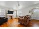 Cozy living room with hardwood floors and a brick fireplace, offering a warm and inviting atmosphere at 5674 S Prescott St, Littleton, CO 80120