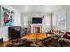 Comfortable living room featuring a decorative fireplace, hardwood floors, and natural light from two windows at 5674 S Prescott St, Littleton, CO 80120