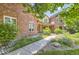 Charming brick home with a well-manicured lawn, lush landscaping, and inviting entrance at 4681 S Columbine Ct, Cherry Hills Village, CO 80113
