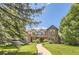 Charming brick and siding home featuring a landscaped front yard, mature trees, and inviting curb appeal at 4681 S Columbine Ct, Cherry Hills Village, CO 80113