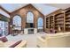 Gathering room with brick wall, vaulted ceiling, and built-ins at 4681 S Columbine Ct, Cherry Hills Village, CO 80113