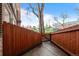 Private backyard space with a wooden fence, mature tree, and a small patio area perfect for outdoor seating at 2867 Jasmine St, Denver, CO 80207