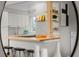 Bright kitchen featuring white cabinets, wooden countertops, barstool seating, and decorative shelving at 2867 Jasmine St, Denver, CO 80207