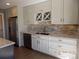 Modern kitchen with white cabinets, stainless steel appliances, and stylish backsplash at 7982 S Kittredge Way, Englewood, CO 80112