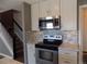 Kitchen with stainless steel appliances, neutral tile backsplash, and stairs at 7982 S Kittredge Way, Englewood, CO 80112