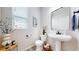 Bright, modern half bathroom with pedestal sink, stylish decor, and a window with natural light at 4585 High Mesa Cir, Castle Rock, CO 80108