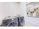 Functional laundry room with modern machines and artistic decor at 4585 High Mesa Cir, Castle Rock, CO 80108