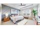 Serene bedroom featuring a decorative accent wall, tray ceiling, and bright windows at 4585 High Mesa Cir, Castle Rock, CO 80108